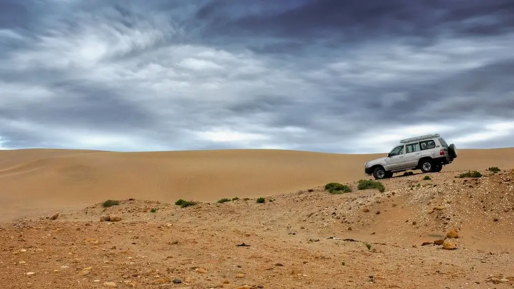 An overland vehicle with the Kuafo inflatable roof top tent deployed at sunset on a remote ridge